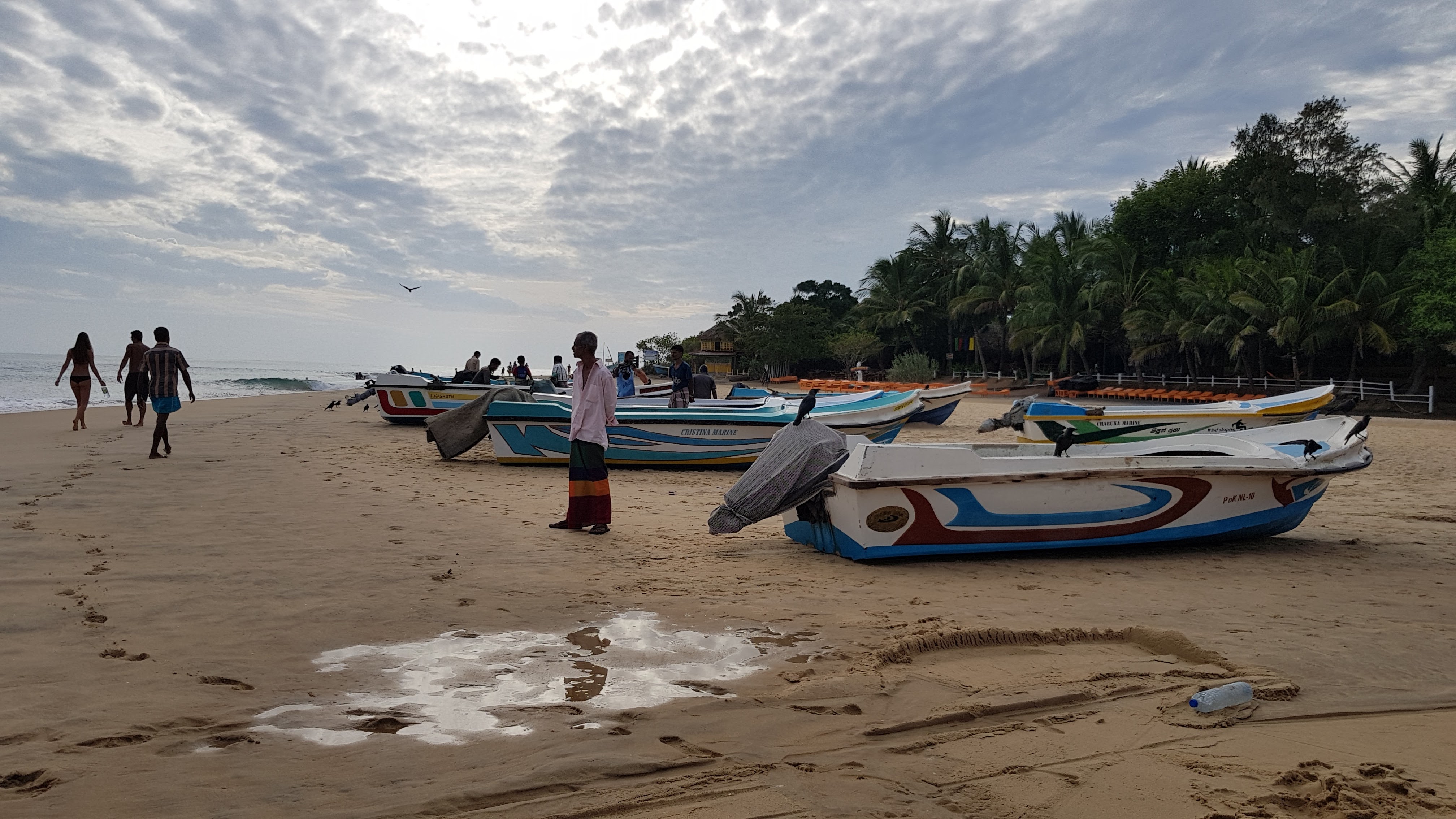 Brightly painted fishing boats drawn up on the beach at Arugam Bay