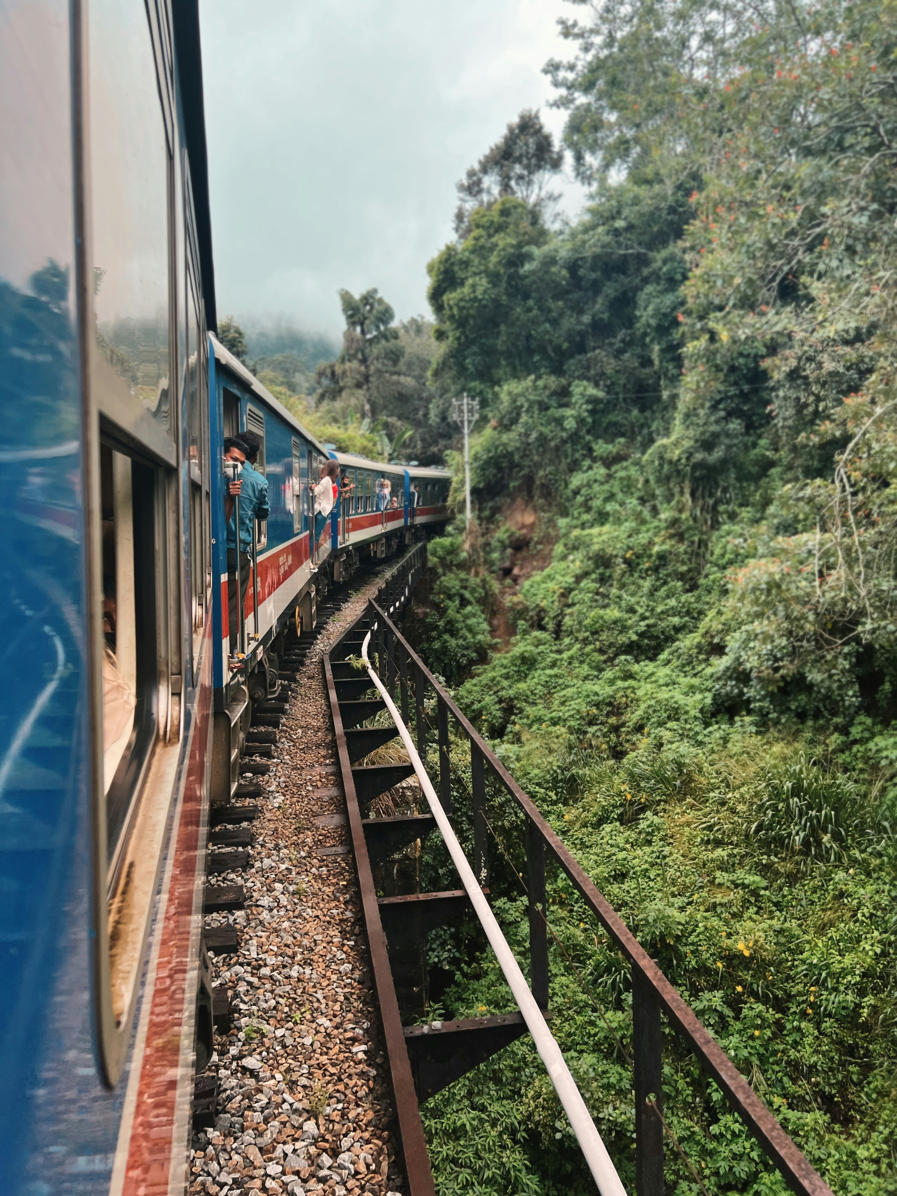 Blue Sri Lankan train crossing a hill-country bridge