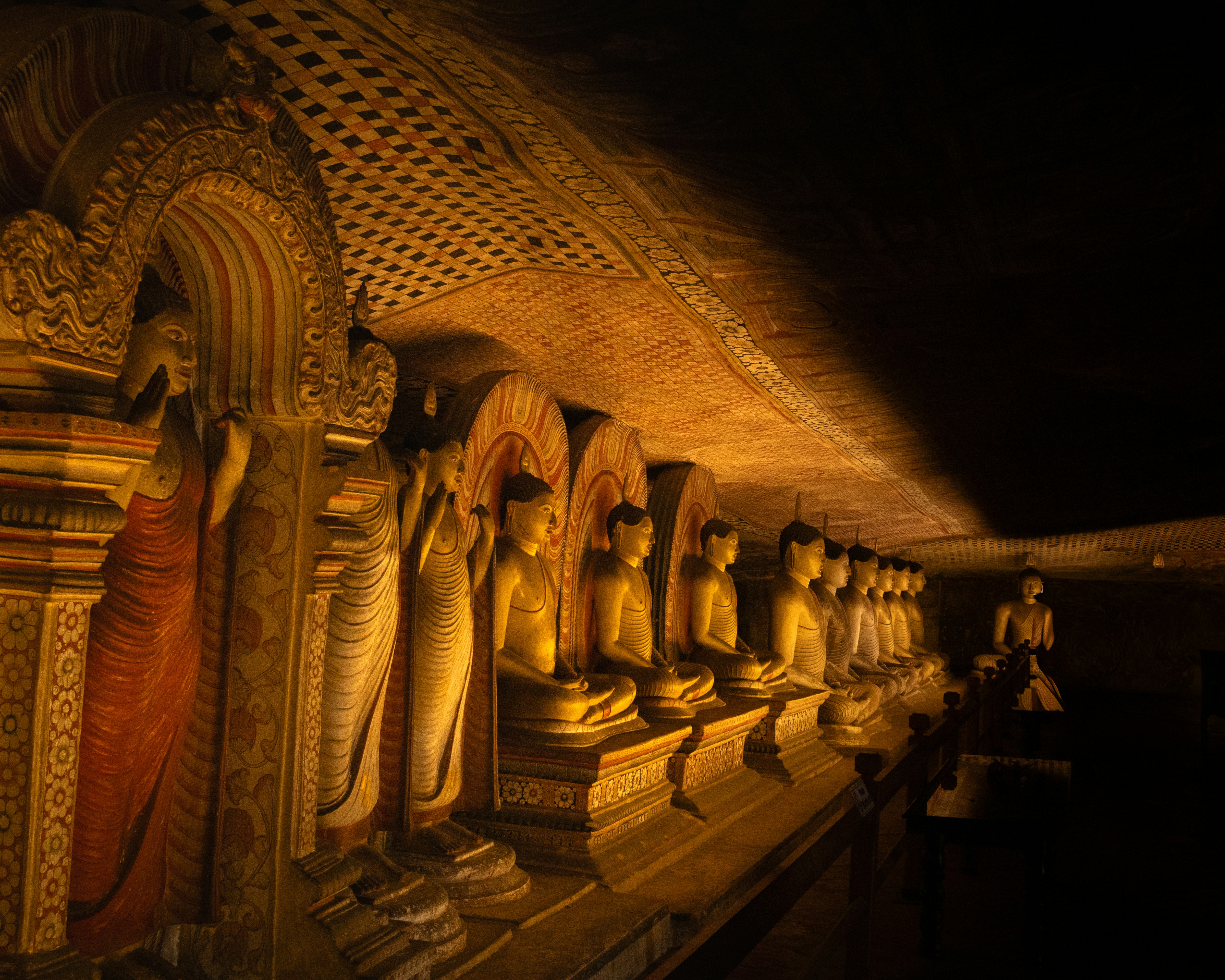 Row of golden Buddhas in Dambulla cave temple