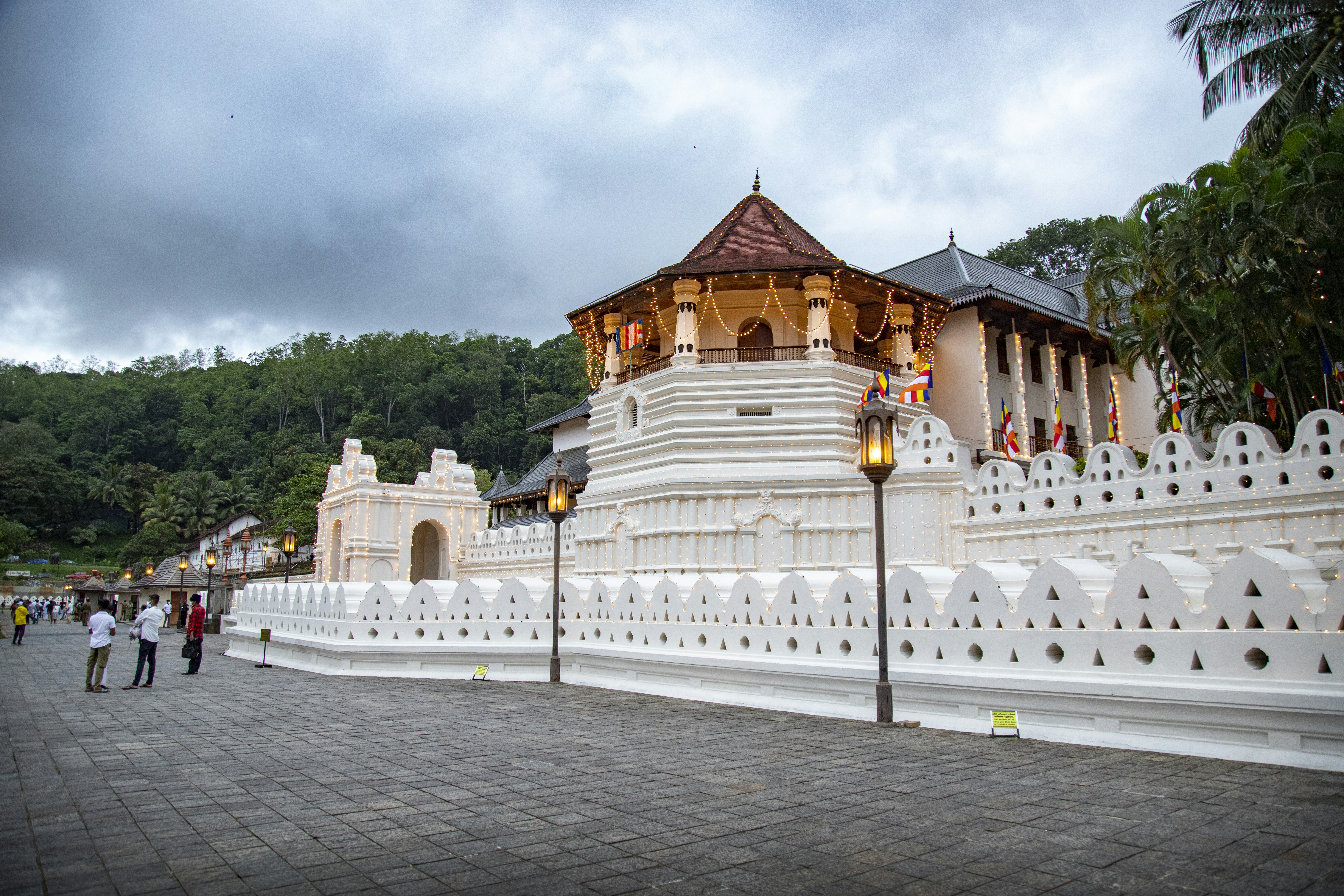Temple of the Tooth strung with lights under a heavy evening sky, Kandy